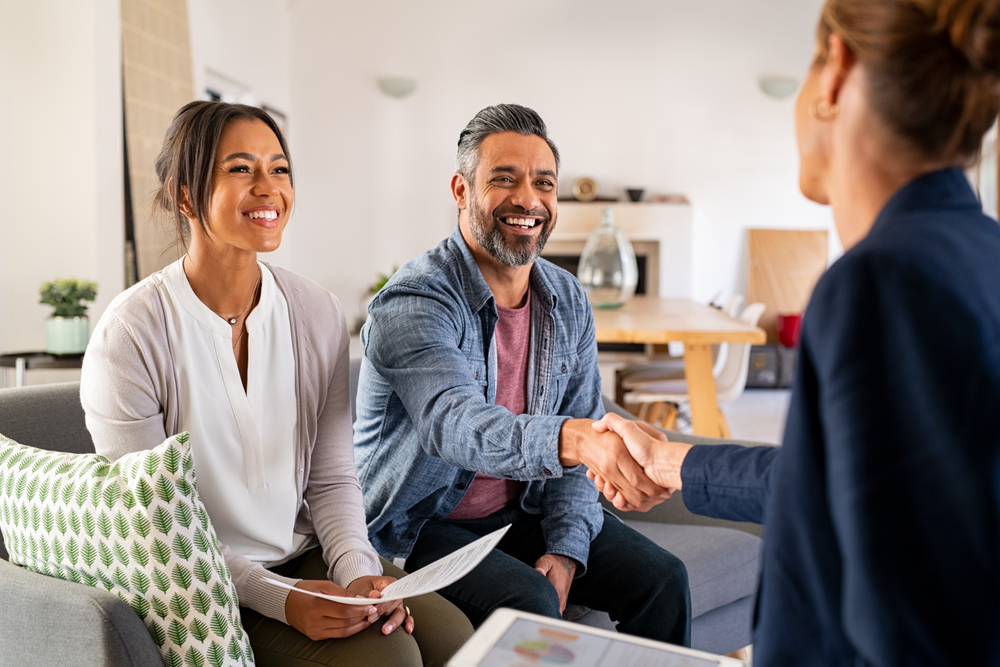 An insurance agent shakes hands with his clients.